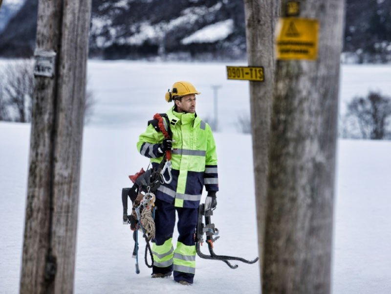 person in workwear clothing with reflective tape in snow